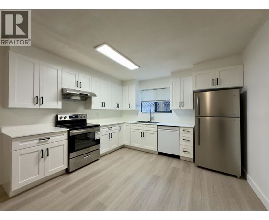 A kitchen with white cabinets and stainless steel appliances.