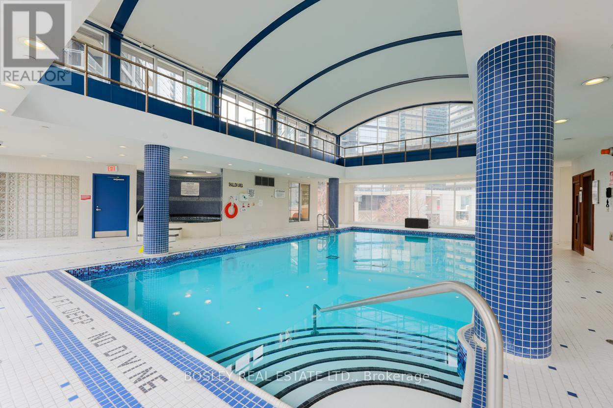 A swimming pool inside a building with a blue tiled wall.
