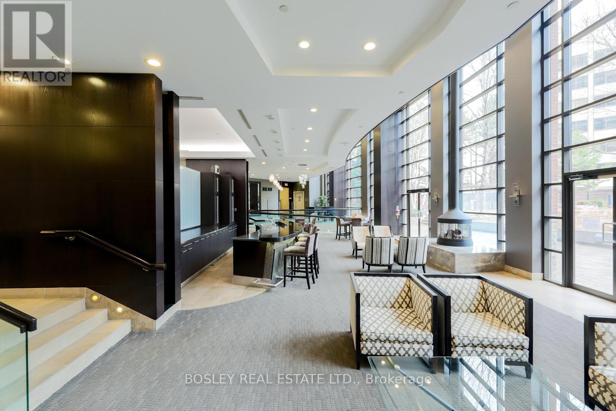 A spacious office lobby with a staircase and a glass railing.