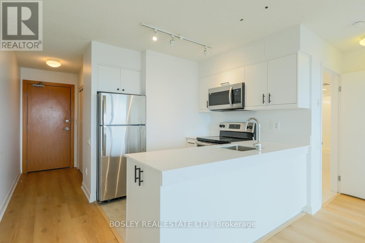 A kitchen with white cabinets and a refrigerator.