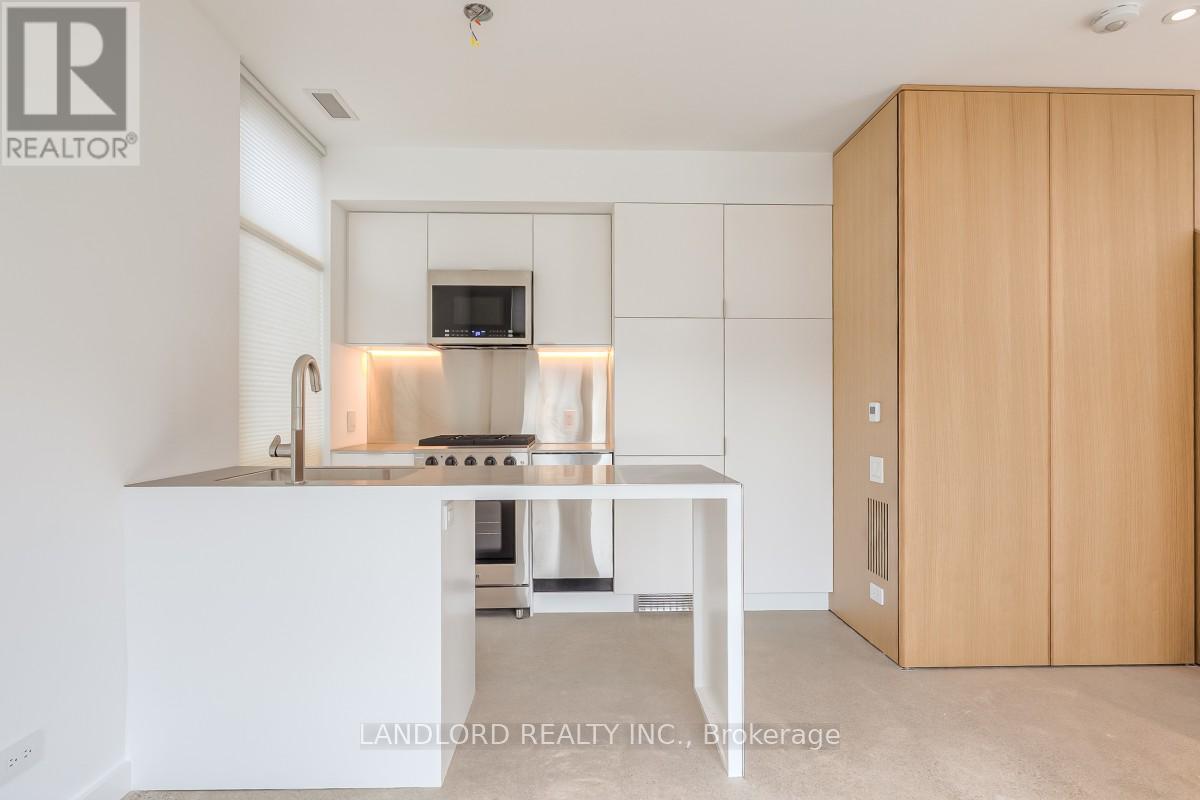 A modern kitchen with a white countertop and a wooden cabinet.