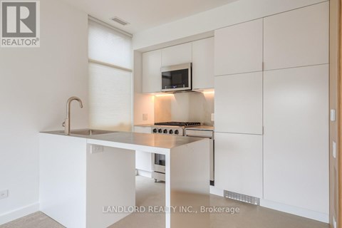 A modern kitchen with white cabinets and a stainless steel island.