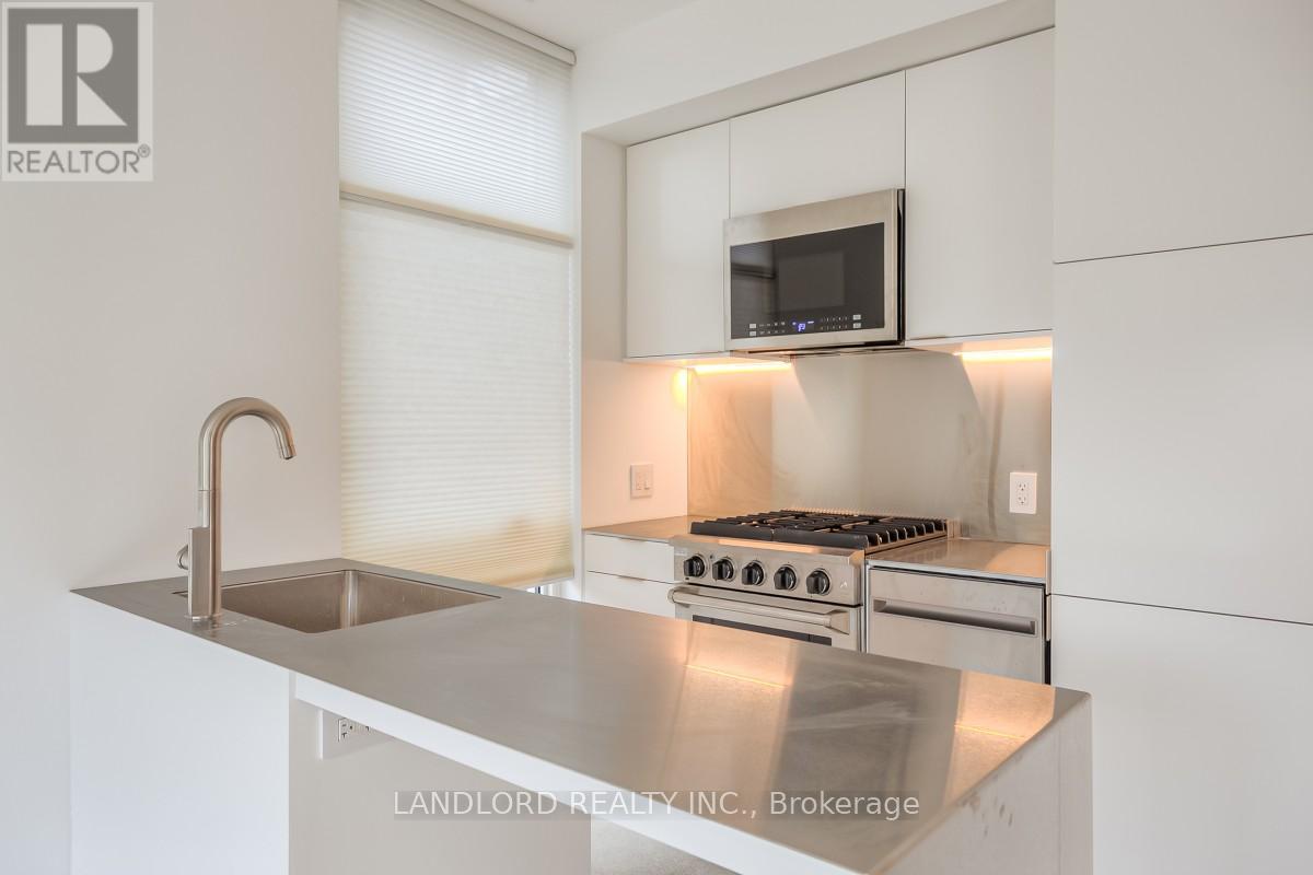 A modern kitchen with stainless steel appliances and white cabinets.