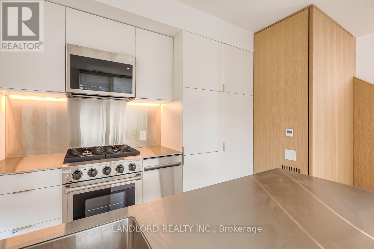 A modern kitchen with a stove and a microwave above it.