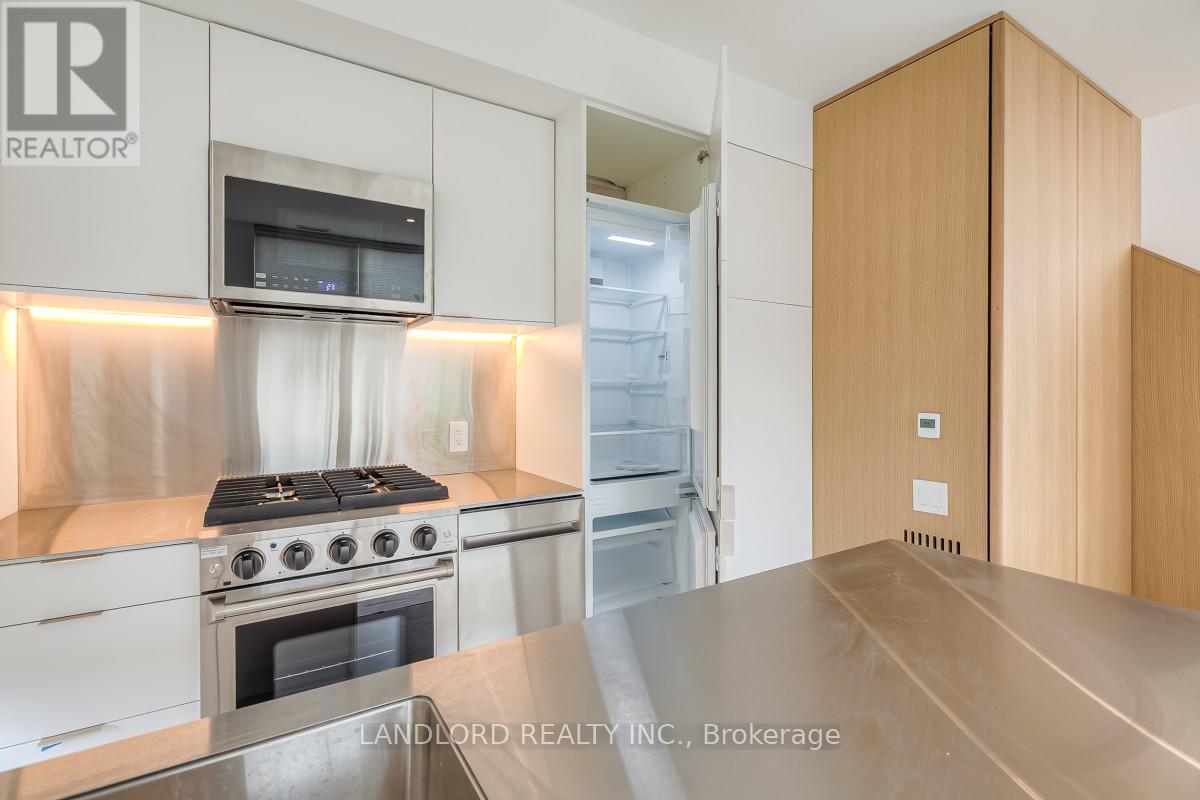 A modern kitchen with a stainless steel stove and white cabinets.