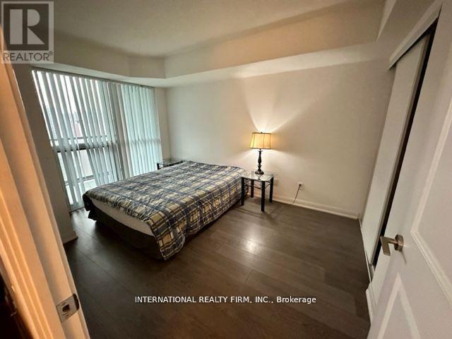 A bedroom with a bed, nightstand, and lamp.