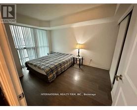 A bedroom with a bed, nightstand, and lamp.
