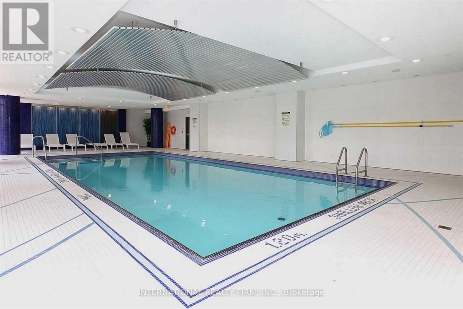 A large indoor swimming pool with a glass bottom and a white ceiling.