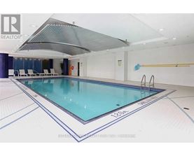 A large indoor swimming pool with a glass bottom and a white ceiling.