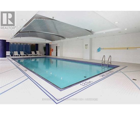 A large indoor swimming pool with a glass bottom and a white ceiling.