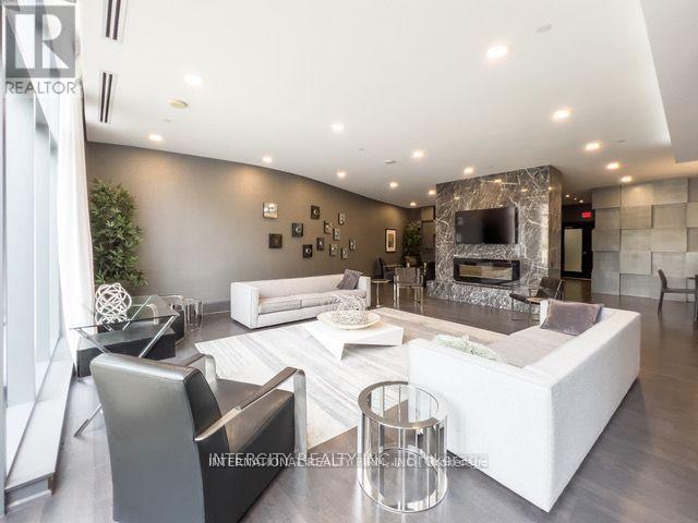 A modern living room with a white sofa set and a stone fireplace.