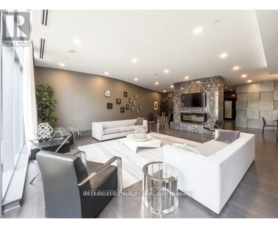 A modern living room with a white sofa set and a stone fireplace.