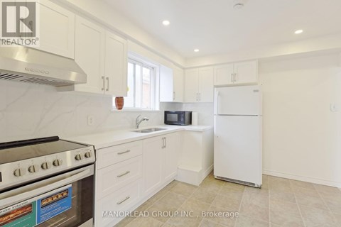 A kitchen with white cabinets and a stove top oven.