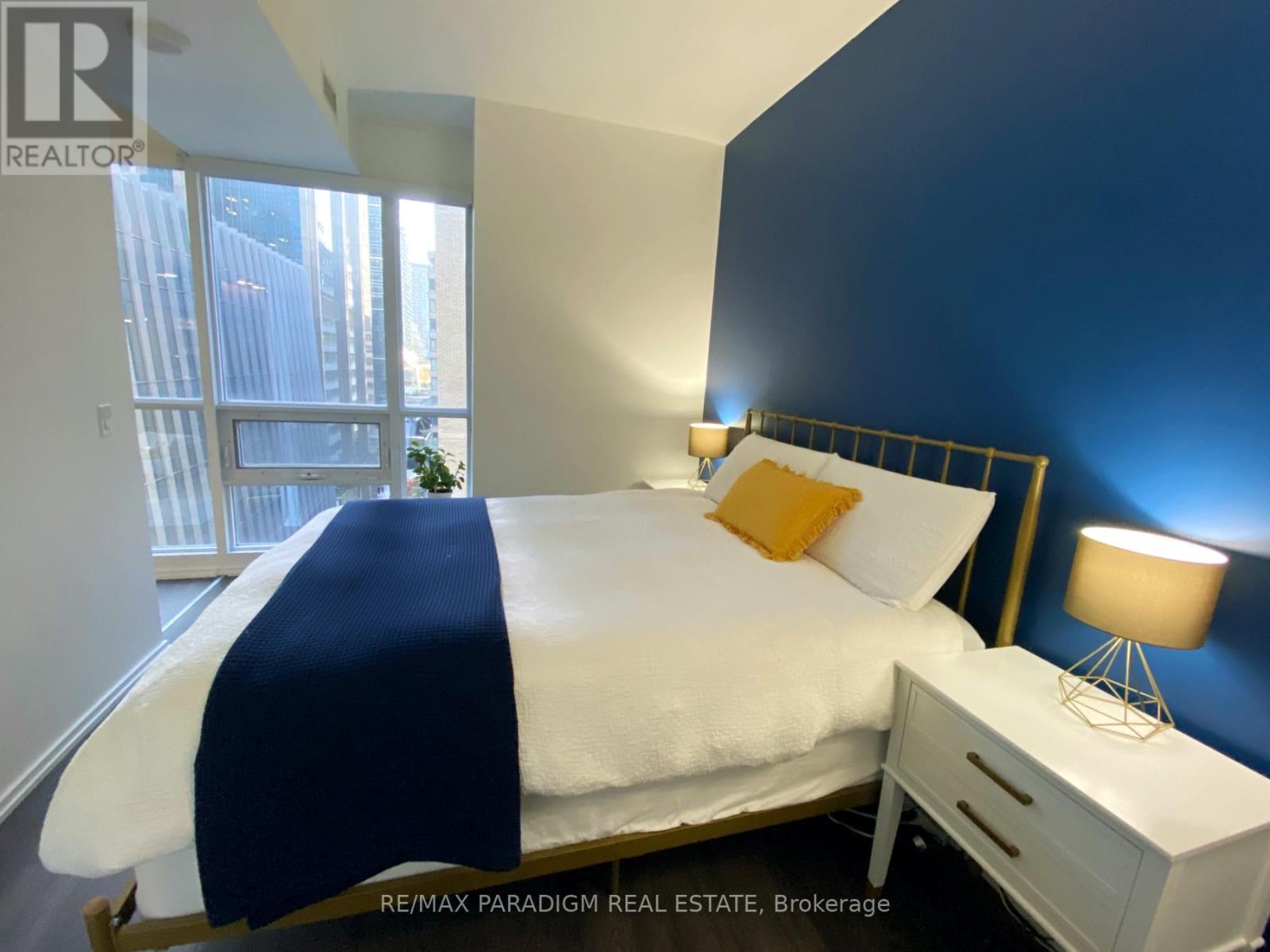 A bedroom with a white bed and a blue blanket.