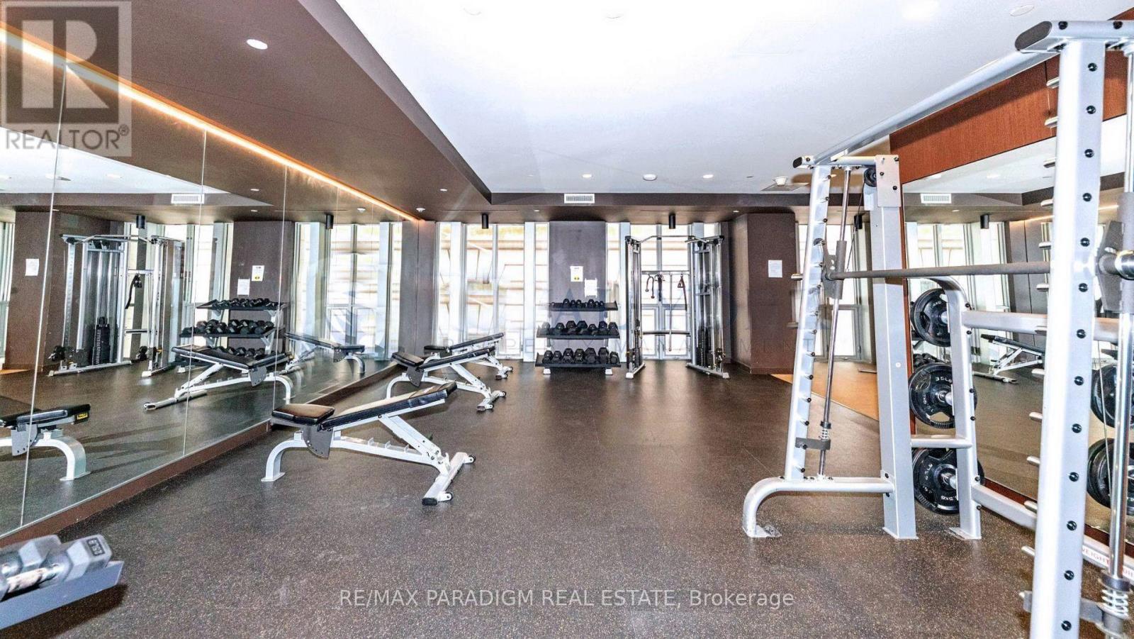 A gym with a variety of equipment including treadmills, weights, and exercise machines.