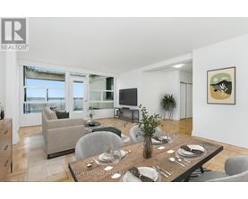 A modern dining room with a wooden table set for two.