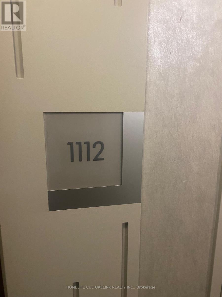 A sign with the number 1112 is mounted on a wall.