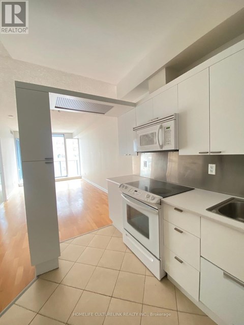 A kitchen with white cabinets and appliances is for sale.