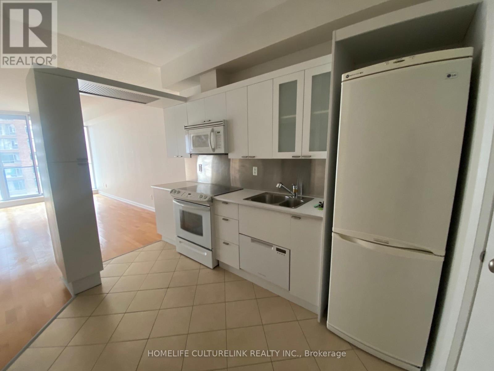 A kitchen with white appliances and cabinets.