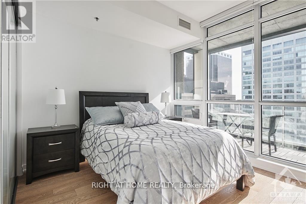 A bedroom with a large bed and a view of the city.