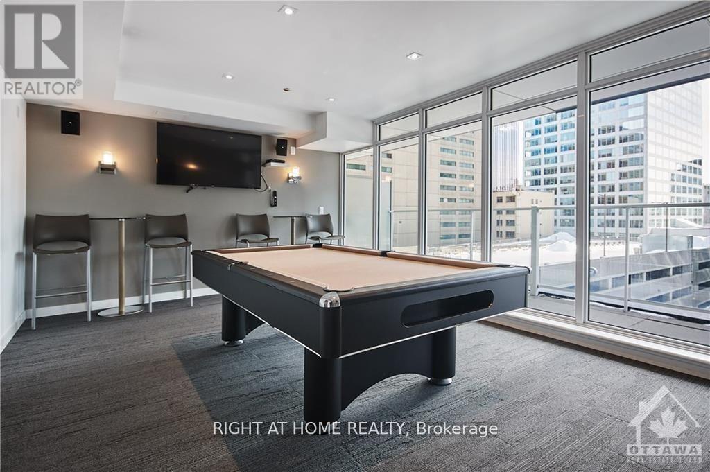 A room with a pool table and a tv mounted on the wall.