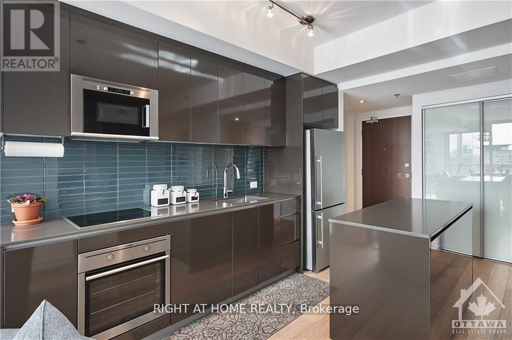 A modern kitchen with a stainless steel refrigerator and a microwave above the stove.