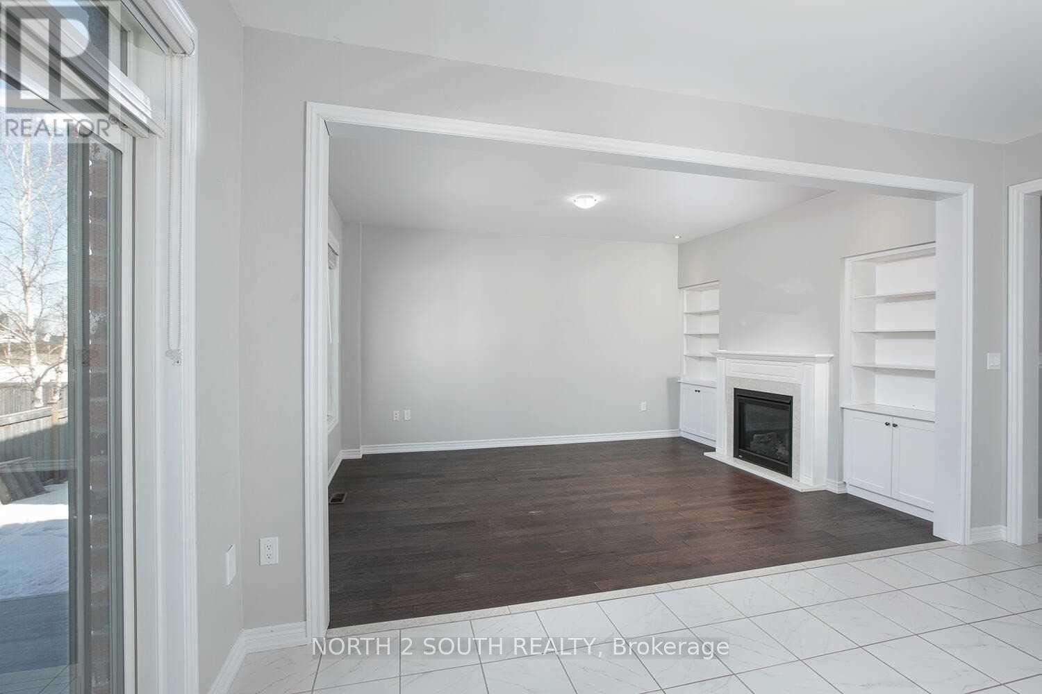 A spacious living room with a fireplace and built-in shelves.