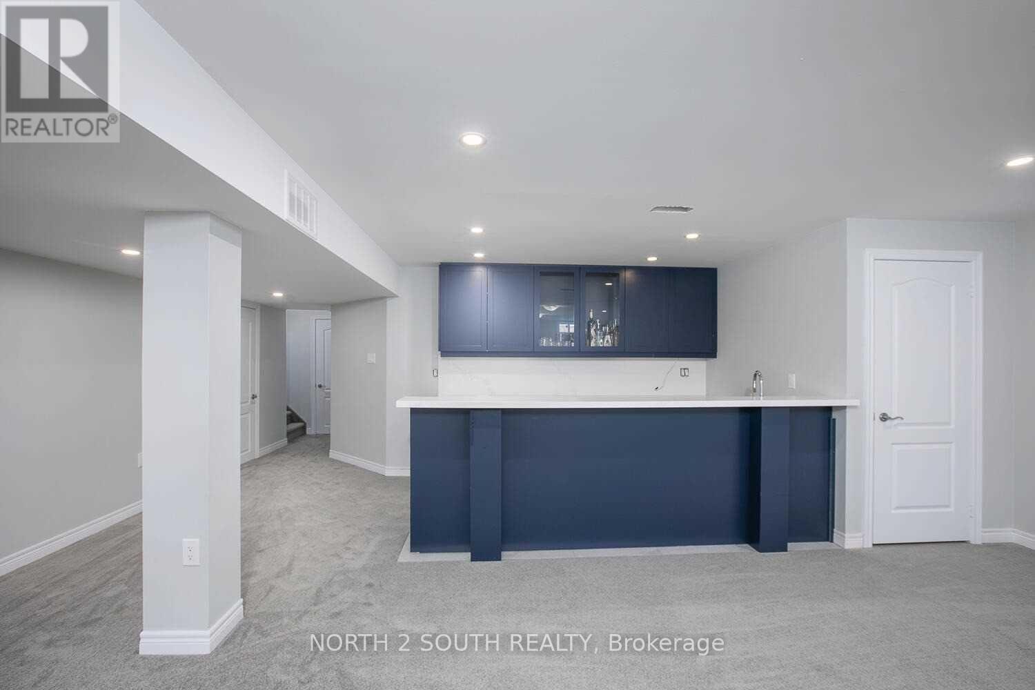 A spacious room with a bar area and a door on the right side.