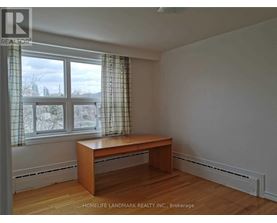 A room with a desk and a window with curtains.