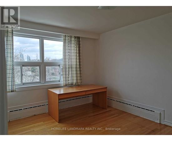 A room with a desk and a window with curtains.