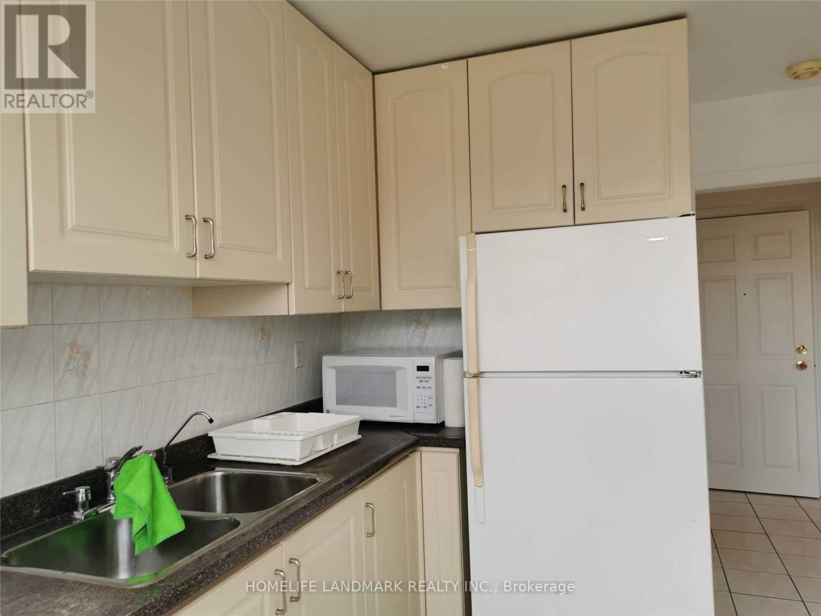 A kitchen with a sink, microwave, and refrigerator.