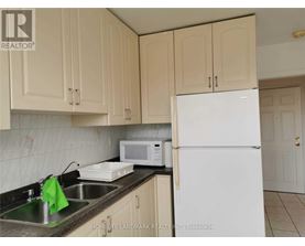 A kitchen with a sink, microwave, and refrigerator.