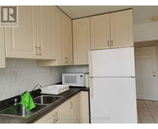 A kitchen with a sink, microwave, and refrigerator.
