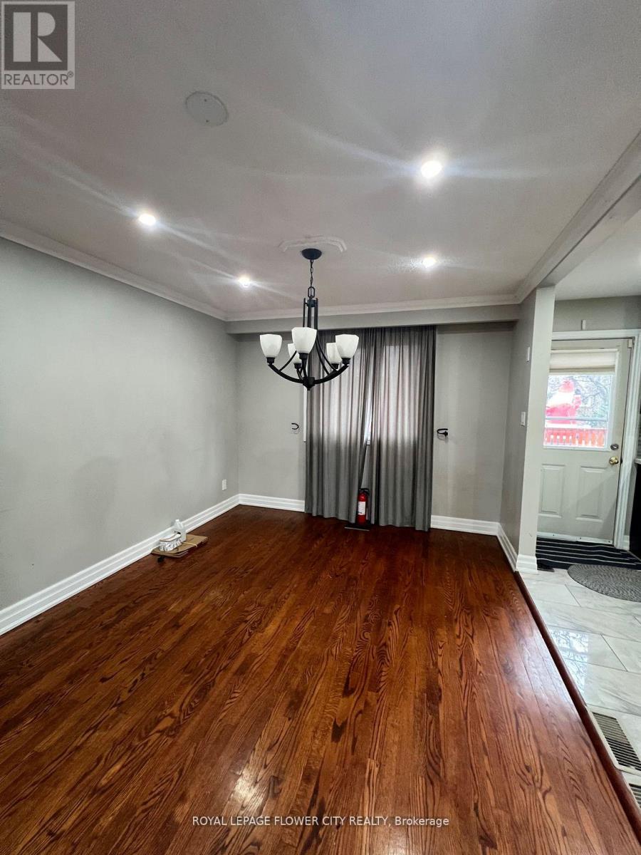 A room with wooden flooring and a chandelier.