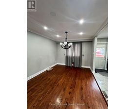 A room with wooden flooring and a chandelier.