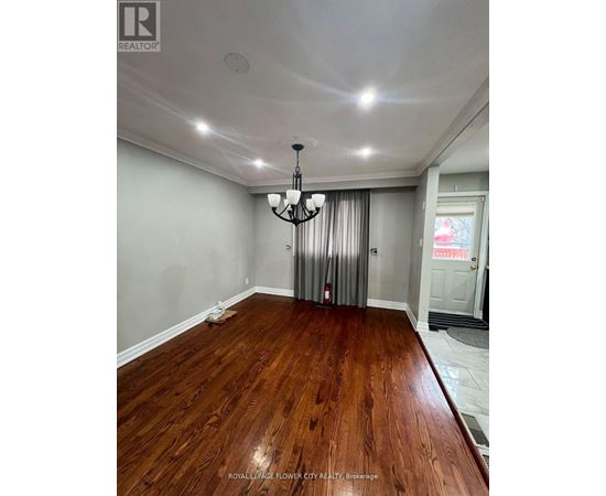 A room with wooden flooring and a chandelier.