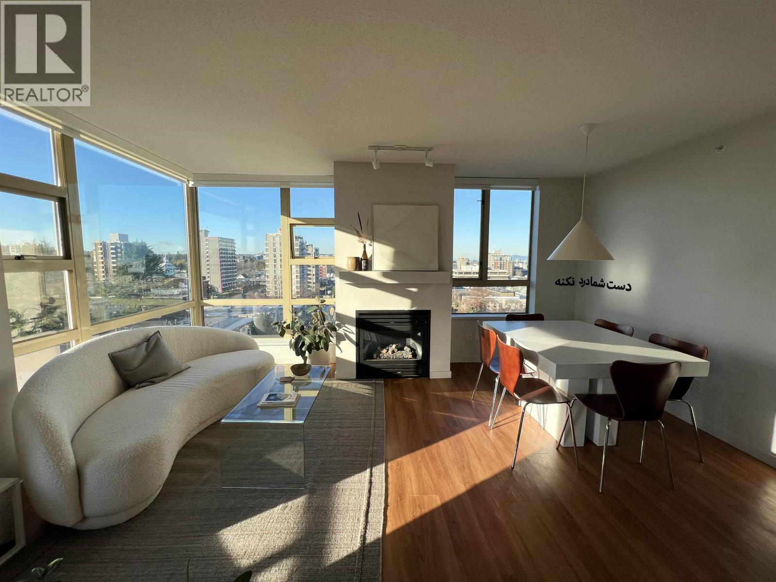 A living room with a white couch and a fireplace.
