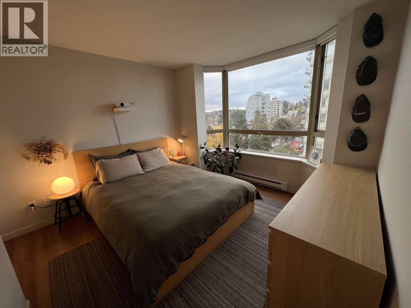 A bedroom with a large bed and a view of the city.