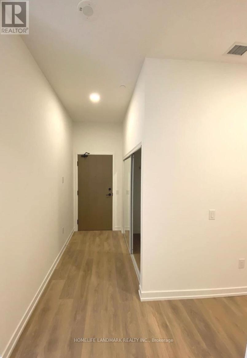 A long hallway with a brown door at the end.