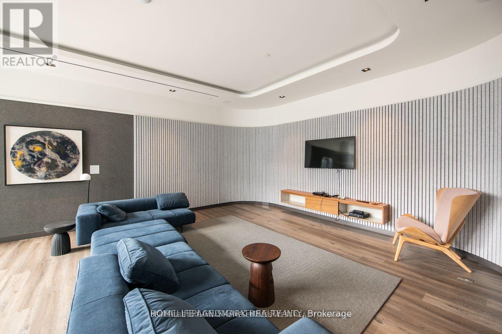 A modern living room with a blue couch and a television.