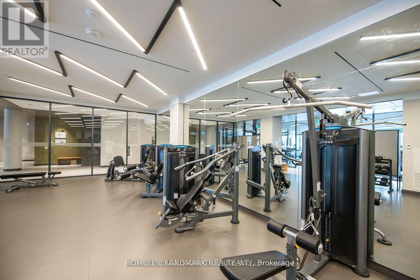 A gym with a variety of equipment including treadmills, weights, and exercise machines.