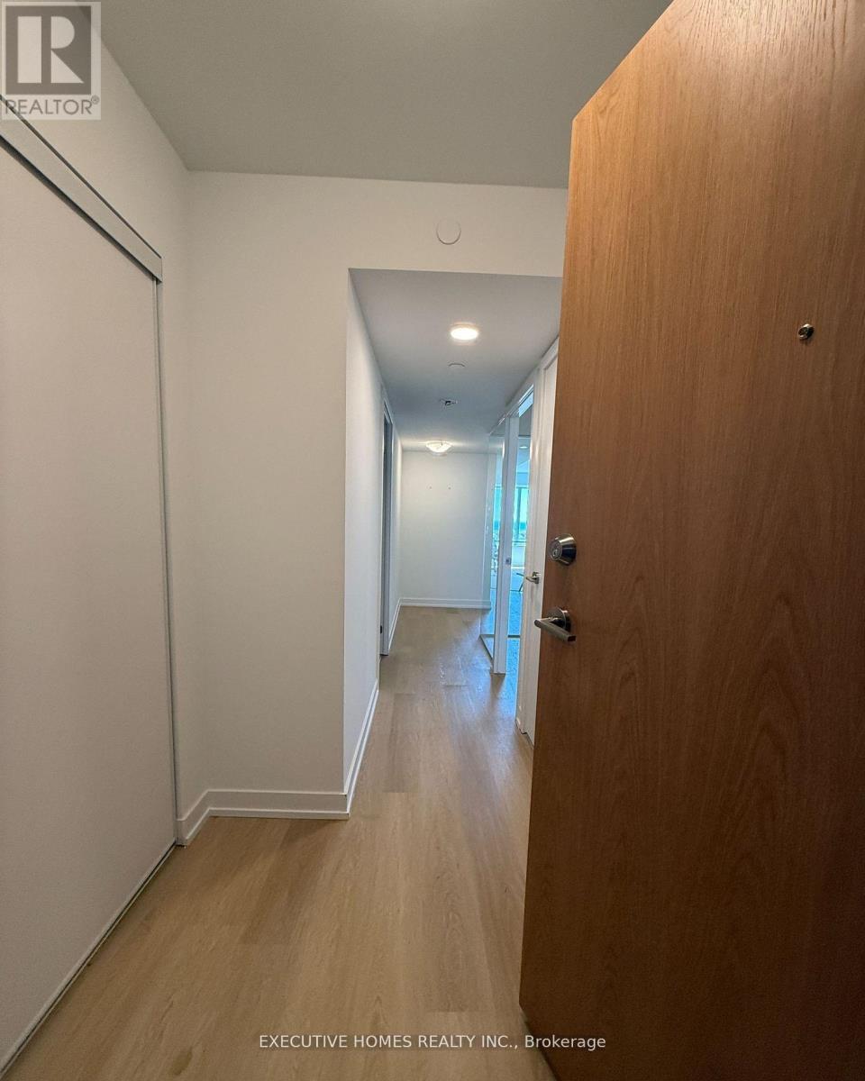A hallway with a wooden door on the right.