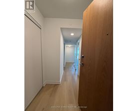 A hallway with a wooden door on the right.