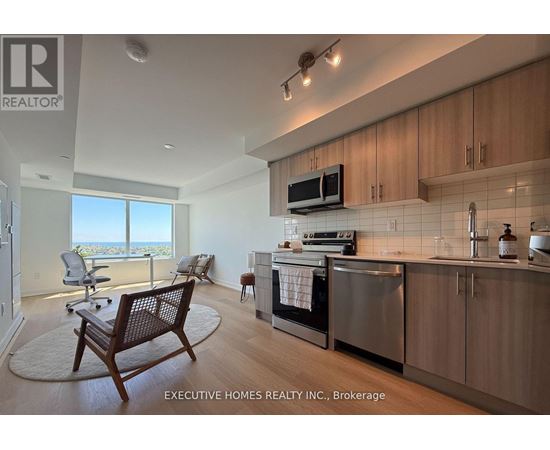 A modern kitchen with wooden cabinets and a large window overlooking the ocean.