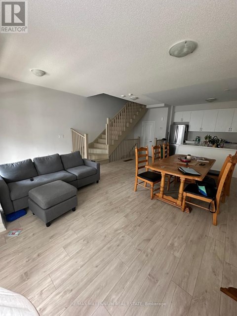 A living room with a grey couch and a wooden table.
