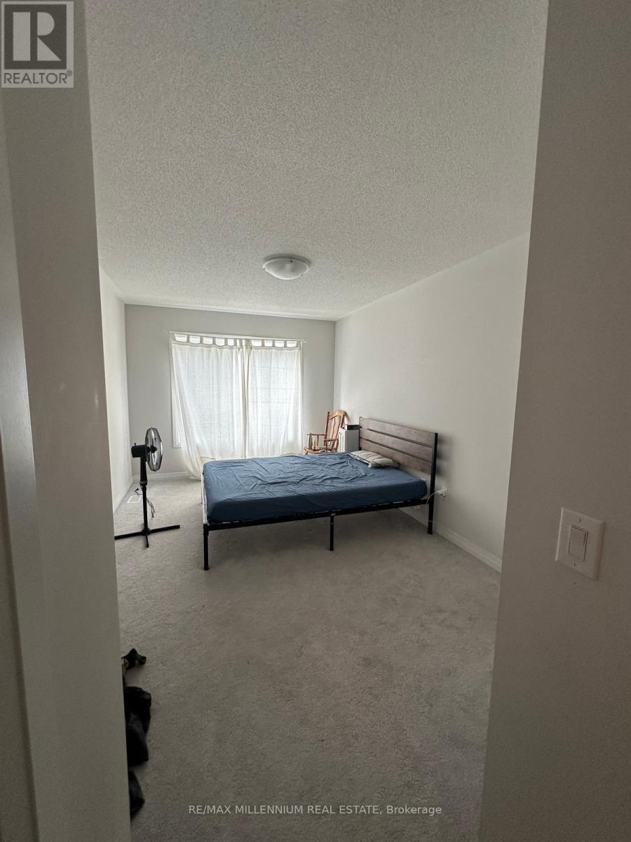 A bedroom with a bed, a fan, and a window with curtains.