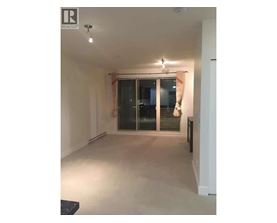 A spacious room with a sliding glass door and a black bench.