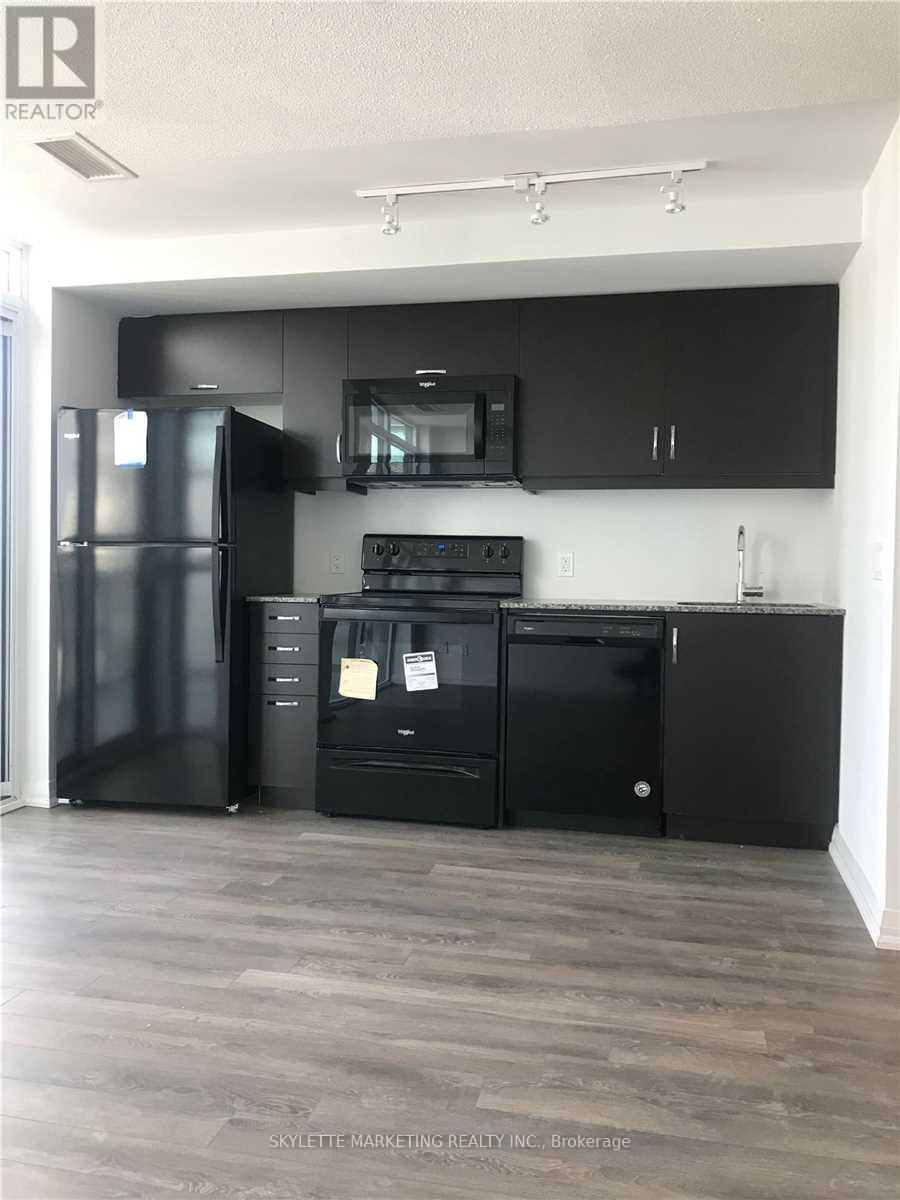 A kitchen with black appliances and cabinets.