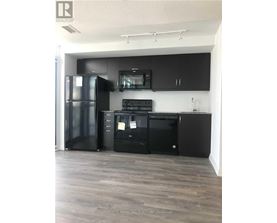A kitchen with black appliances and cabinets.
