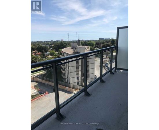 A balcony with a view of a cityscape and a building under construction.